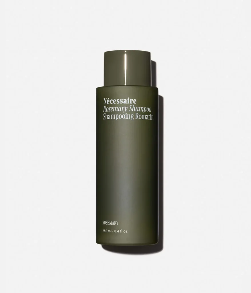 A minimalist green bottle of Nécessaire The Shampoo with Rosemary, a premium clean-beauty shampoo for women focused on scalp health and hair growth.